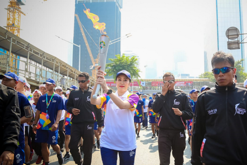 Direktur Konsumer Bank BRI Handayani membawa obor Asian Games 2018.