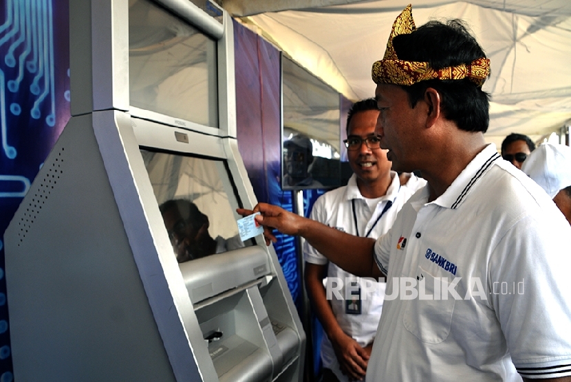Direktur Konsumer Bank BRI Sis Apik Wijayanto menunjukkan cara penggunaan layanan Self Service Banking (SSB) di Teras Digital BRI saat berlangsung bazaar “Inklusi Keuangan Untuk Rakyat,” Sabtu (29/10), di lapangan Palembang Trade Center.
