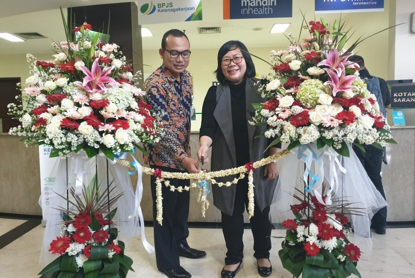 Direktur Omni Hospitals Pulomas, Hanny Merliana dan Kepala Bidang Pelayanan BPJSTK Cabang Rawamangun, Jakarta Timur, Tri Pambudi Santoso menggunting pita tanda kerja sama keduanya dimulai