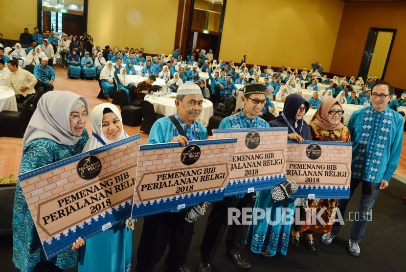 Direktur Operasional Bank BJB Fermiyanti (kiri), Direktur Konsumer Suartini (kedua kanan) dan Pimdiv Kredit Konsumer Bank BJB Triastoto Hardjanto Wibowo (kanan) berfoto bersama dengan perwakilan penerima paket perjalanan religi saat pelepasan keberangkatan pemenang perjalanan religi Consumer Loan Loyalty Program Bank BJB 2018, di Hotel Aryaduta, Kota Bandung, Jumat (8/2).