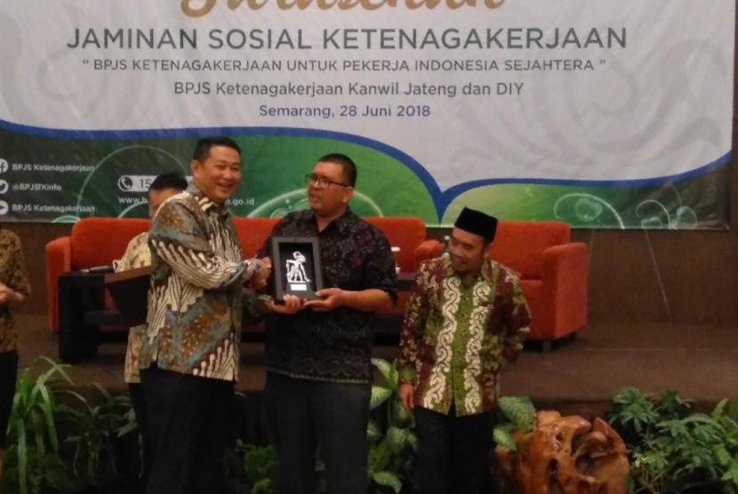Direktur Pelayanan BPJS Ketenagakerjaan Krishna Syarif memberikan kenang-kenangan kepada pemerhati jaminan sosial Timboel Siregar dalam sebuah sarasehan di Semarang, Jawa Tengah, Kamis (27/6).