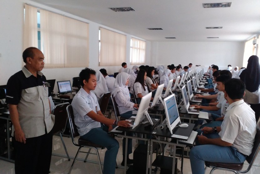 Direktur Pendidikan Sekolah Bosowa Bina Insani (SBBI) Sudirman (kiri) mengawasi siswa kelas XII SMA BBI yang tengah mengikuti simulasi Ujian Nasional Berbasis Komputer (UNBK), Senin (20/2/2017).