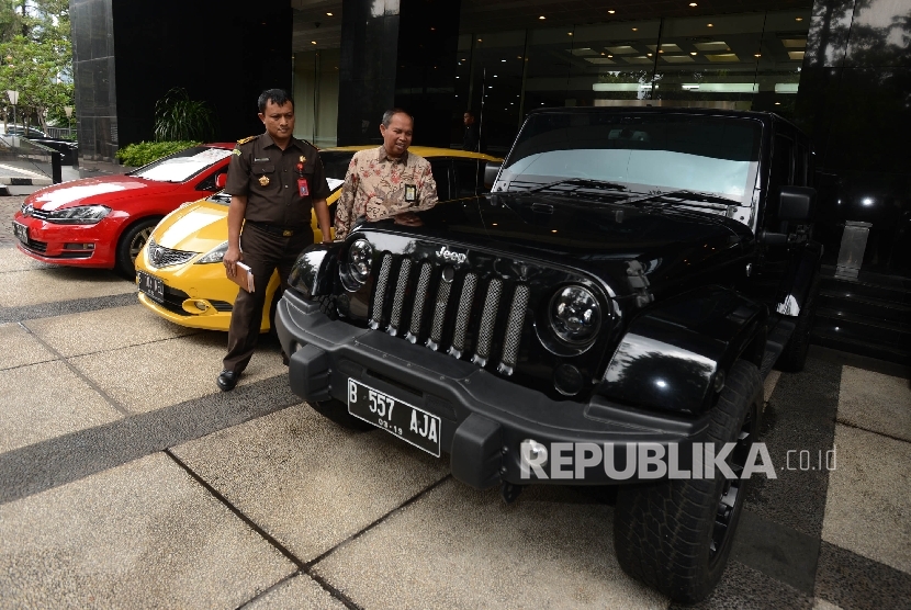 Direktur Penegakan Hukum DJP Dadang Suwarna (kanan) didampingi petugas kejaksaan memeriksa barang bukti kendaraan mewah yang disita terkait kasus dugaan tindak pidana pencucian uang (TPPU) dengan tersangka Amie Hamid di Kantor Pusat Dirjen Pajak, Jakarta, 