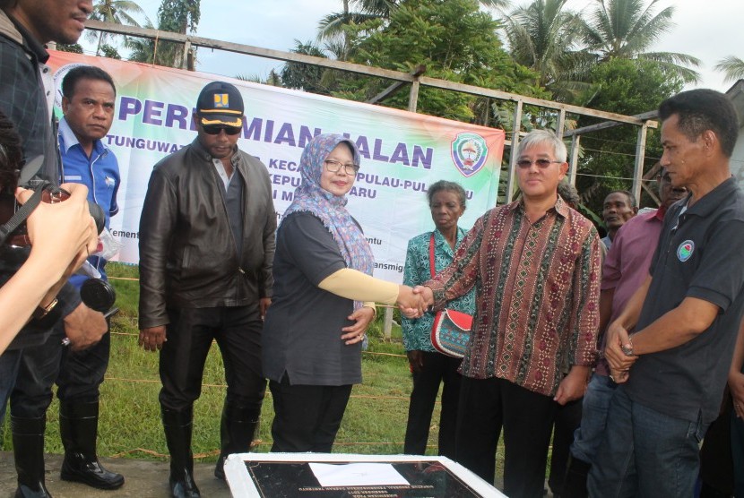 Direktur Pengembangan Daerah Perbatasan, Direktorat Jenderal Pengembangan Daerah Tertentu (Ditjen PDTu), Kemendes PDTT, Endang Supriyani (berkerudung), bersalaman dengan Bupati Kepulauan Aru, Johan Gonga, usai meresmikan jalan desa wilayah perbatasan negara di Desa Tunguwatu-Gorar, Kecamatan Pulau-pulau Aru, Kabupaten Kepulauan Aru, Provinsi Maluku, Sabtu (16/12).  