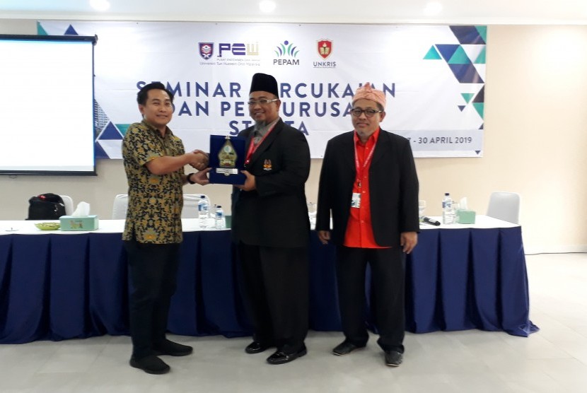 Direktur Penjamin Mutu Universitas Krisnadwipayana, Abdullah Sumrahadi saat memberikan cendera mata ke delegasi dari Malaysia, Ahad (28/4).