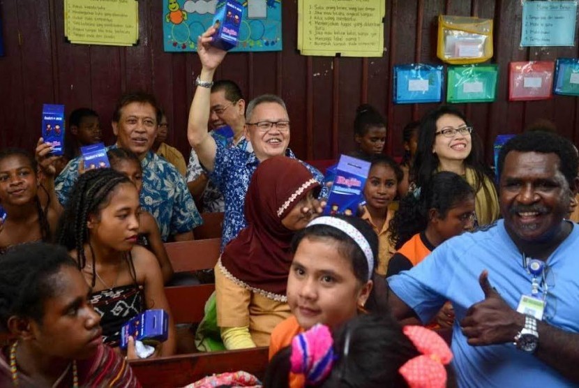 Direktur PT Bank Central Asia Tbk (BCA) Rudy Susanto (tengah) didampingi Executive Vice President CSR BCA Inge Setiawati (kiri) dan Senior Vice President CSR BCA Sapto Rachmadi (kanan) mengangkat kaleng tabungan bersama guru dan siswa siswi SD Negeri Inpres 26 Klamono, Sorong, Papua Barat, Jumat (21/4).