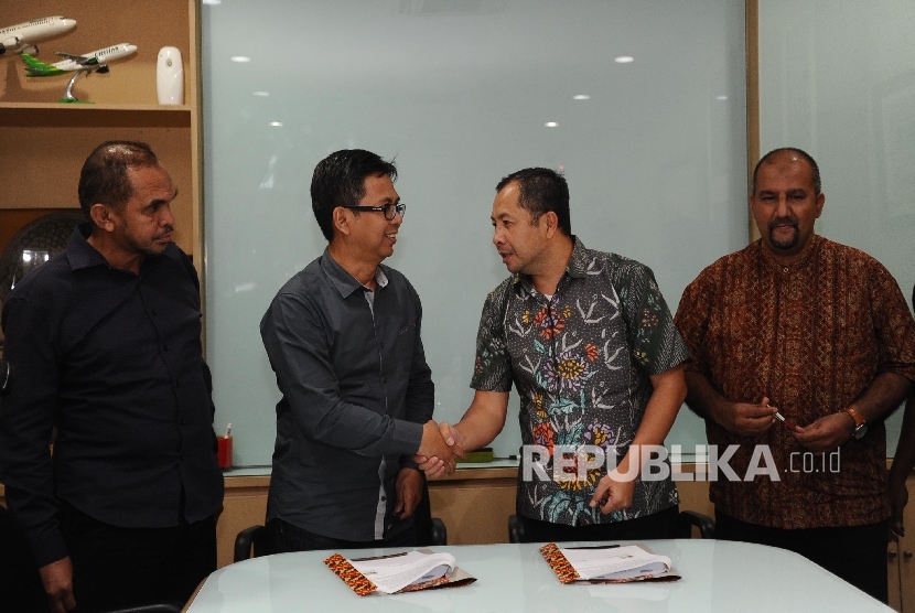 Direktur Republika Penerbit Arys Hilman Nugraha, (kedua kiri), Ketua Ikapi Hikmat Kurnia (kedua kanan) berjabat tangan usai melakukan penandatanganan kerjasama di kantor Harian Republika, Jakarta, Selasa (7/3).
