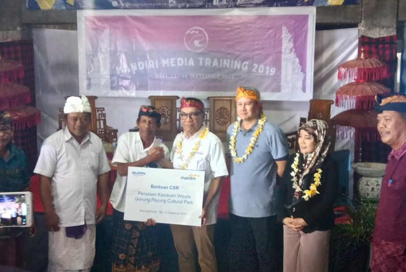 Direktur Retail Banking Bank Mandiri, Donsuwan Simatupang menyerahkan bantuan CSR di Desa Kutuh, Badung, Bali, Kamis (11/9).   