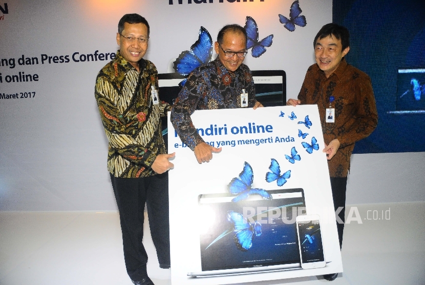 Direktur Retail Banking Bank Mandiri Tardi, Direktur Operations Ogi Prastomiyono , dan SEVP Chief Technology Officer Joseph Godong (dari kiri) menunjukan layanan Mandiri Online saat peluncuran mandiri Online di Jakarta.