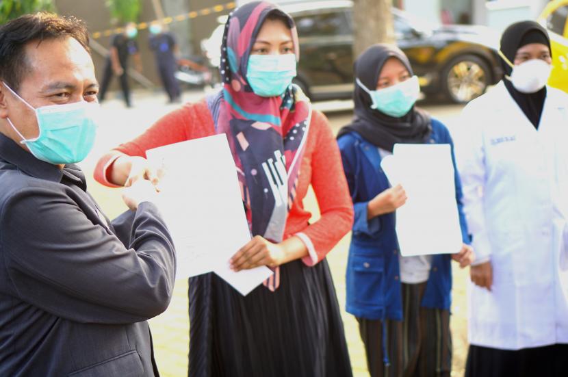 Direktur RSUD dr. Iskak Tulungagung, dr. Supriyanto Dharmoredjo, Sp.B, M.Kes (kiri) menyerahkan surat keterangan sehat kepada tenaga medis yang dinyatakan sembuh dari COVID-19 pada hari pertama kebebasan mereka keluar dari rumah karantina di Asrama RSUD dr. Iskak, Tulungagung, Tulungagung, Jawa Timur, Rabu (22/4). (ilustrasi)