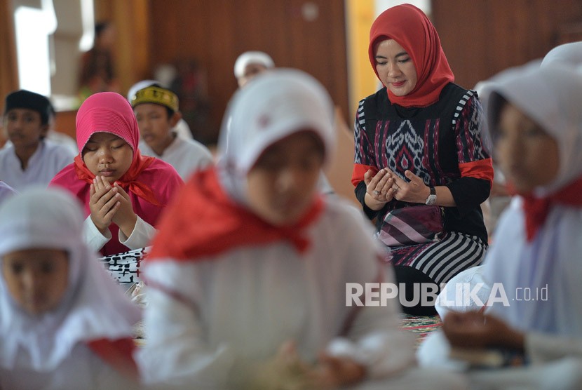 Direktur SDM Pertamina Nicke Widyawati (kanan) berdoa bersama dengan sejumlah anak yatim peserta acara Khataman Alquran di Kantor Pusat Pertamina, Jakarta, Kamis (7/12). 