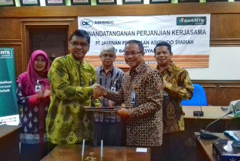 Direktur Utama Askrindo Syariah, Soegiharto (kedua kanan) bertukar naskah PKS dengan Direktur Utama Bank NTB Syariah Kukuh Rahardjo (kedua kiri) dan didampingi oleh Senior Executive Vice President Askrindo Syariah Supardi Najamuddin (kanan)