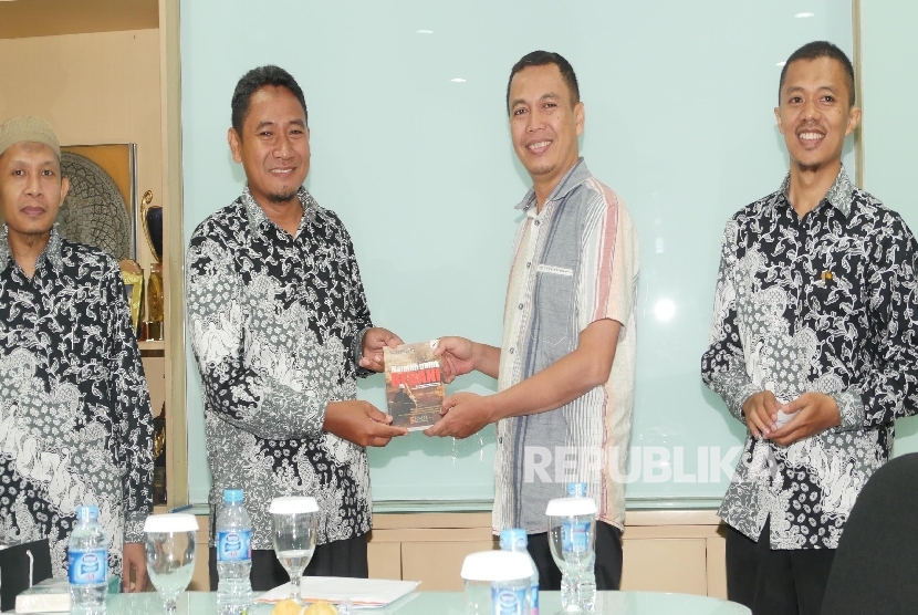 Direktur Utama Baitul Maal Hidayatullah (BMH) Supendi (dua kiri) menerima cenderamata yang diberikan oleh Redaktur Pelaksana Harian Republika Subroto(dua kanan) saat berkunjung ke Republika di Jakarta, Jumat (29/4). (Republika/Musiron)