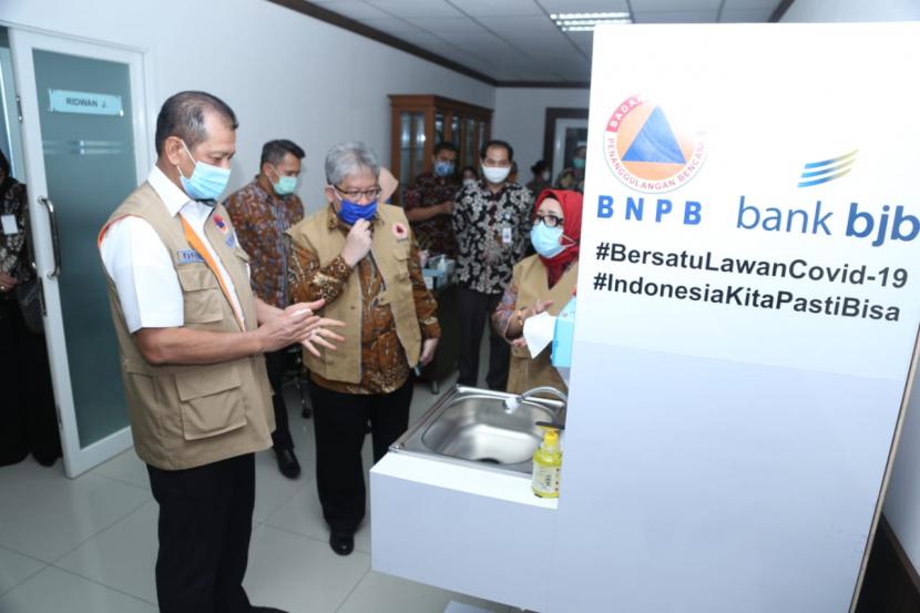 Direktur Utama Bank BJB Yuddy Renaldi (kedua kanan) dan Kepala BNPB Doni Monardo meninjau paket bantuan penanganan Covid-19 yang dititipkan melalui Gugus Tugas Percepatan Penanganan Covid-19 di BNPB, Jakarta, Selasa (14/7).  