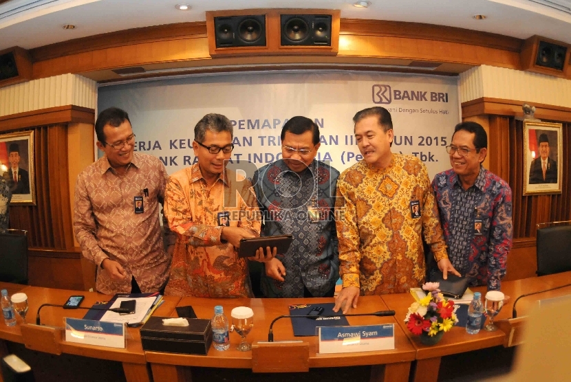 Direktur Utama Bank BRI, Asmawi Syam (tengah) serta Wakil Direktur Utama Bank BRI, Sunarso (kedua kiri) berbincang dengan jajaran direksi sebelum memberikan paparan kinerja triwulan III tahun 2015 Bank BRI di Gedung BRI Jakarta, Kamis (22/10). 