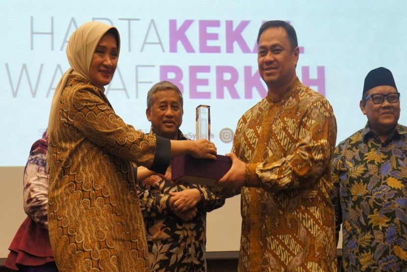 Direktur Utama Bank Mega Syariah Emmy Haryanti (kiri) memberikan piagam kepada Founder ESQ Ary Ginanjar Agustian (kedua dari kanan). Sebelumnya BMS dan perjanjian kerja sama dengan Yayasan Wakaf Bangun Nurani Bangsa (YWBNB) atau sering disebut Yayasan Wakaf ESQ, di Kantor Bank Mega Syariah, Rabu (21/3)