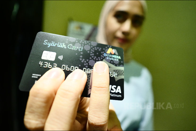Nasabah Bank Mega Syariah sedang menunjukkan kartu BMS.