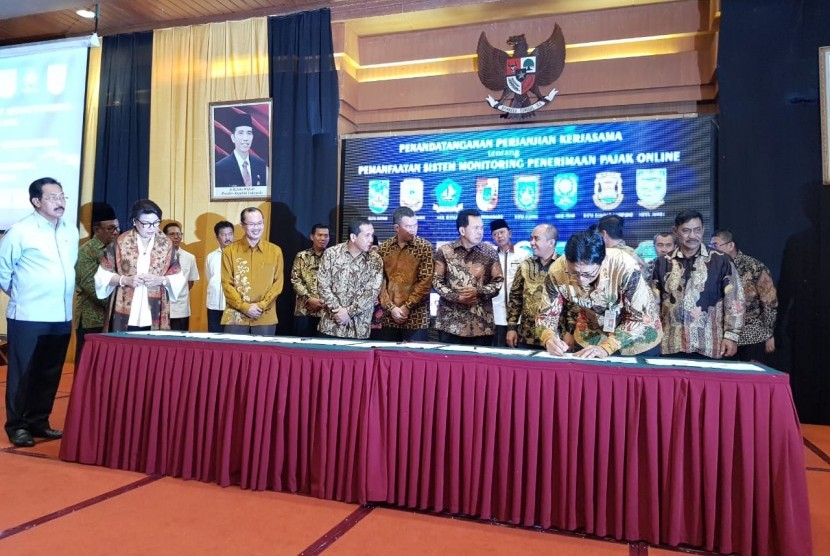Direktur Utama Bank Sumsel Babel Muhammad Adil menyaksikan pada wali kota dan bupati dari Sumatera Selatan (Sumsel) dan Bangka Belitung (Babel) menandatangani naskah kerjasama pemanfaatan sistem monitoring penerimaan pajak online yang ditandatangani di Batam, Rabu (28/11). 