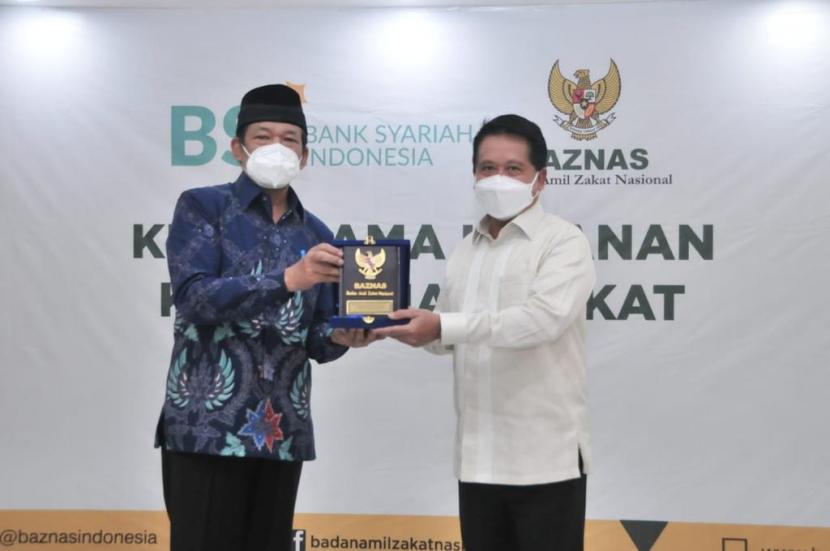 Direktur Utama Bank Syariah Indonesia Hery Gunardi (kanan) dan Ketua BAZNAS, KH. Noor Achmad (kiri) menunjuk komitmen sinergi saat Penandatanganan MoU Kerjasama Layanan Kemudahan Zakat antara BSI dan BAZNAS, Rabu (14/4).