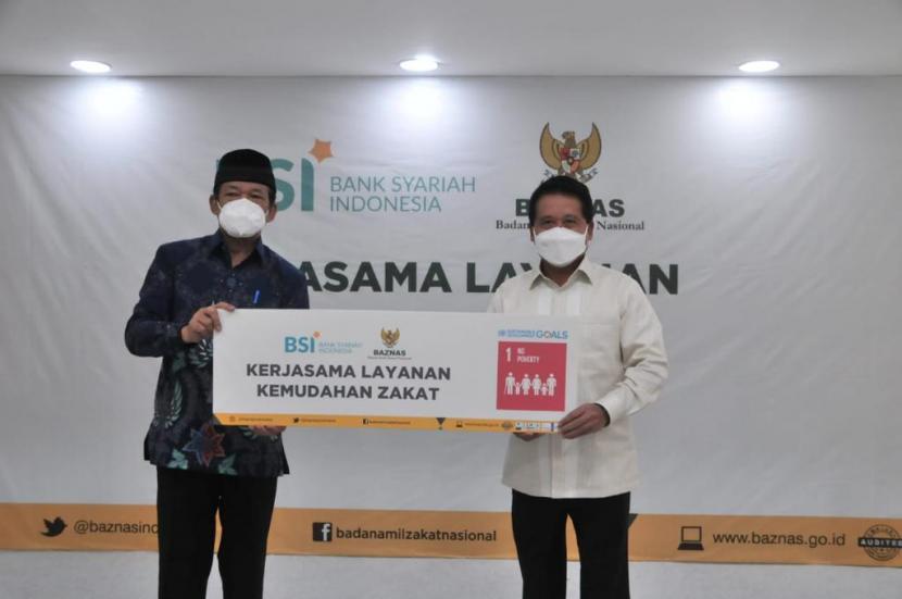 Direktur Utama Bank Syariah Indonesia Hery Gunardi (kanan) dan Ketua BAZNAS, KH. Noor Achmad (kiri) menunjuk komitmen sinergi saat Penandatanganan MoU Kerjasama Layanan Kemudahan Zakat antara BSI dan BAZNAS, Rabu (14/4).