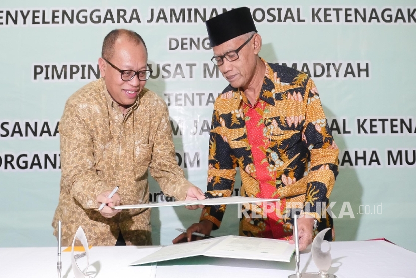 Direktur Utama BPJS Ketenagakerjaan Agus Susanto (kiri) menandatangani nota kesepakatan bersama dengan Ketua Umum PP Muhammadiyah Haedar Nashir di Jakarta, Rabu (5/4). 