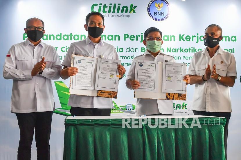 Direktur Utama Citilink Juliandra (kiri) bersama Kepala BNN Heru Winarko (kanan), Direktur Operasi Citilink Erlangga Sakti (kedua kiri) dan Deputi Pencegahan BNN Anjan Pramuka (ketiga kiri) menunjukan dokumen perjanjian kerjasama antara Citilink Indonesia dengan BNN yang usai ditandatangani di Bandara Halim Perdanakusuma, Jakarta, Kamis (15/10/2020). Perjanjian tersebut merupakan upaya Pencegahan dan Pemberantasan Penyalahgunaan dan Peredaran Gelap Narkotika (P4GN) dengan implementasi penempelan stiker pada badan pesawat jenis Airbus A320 dengan tema Say No to Drug, Say Yes to Travel, Stop Narkoba.