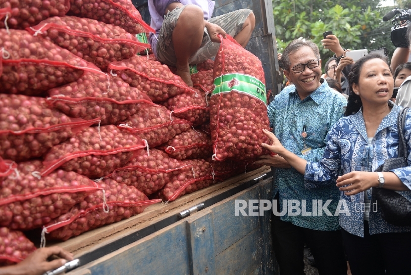 Direktur Utama (Dirut) Bulog, Djarot Kusumayakti (kiri) bersama Menteri BUMN Rini Soemarno melihat bawang merah yang siap dijual dalam operasi pasar di Gudang Bulog Divre Jakarta, Senin (16/5).  (Republika / Wihdan )