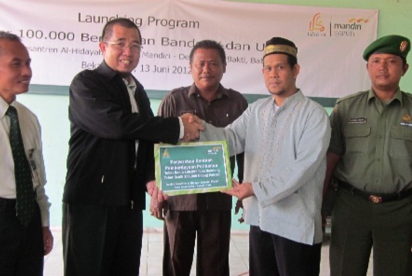 Direktur Utama Laznas BSM Kiagus M Thohir (dua dari kiri) tengah menyerahkan bantuan berupa tiga tambak ikan dengan 200 ribu benih ikan dan udang kepada Pimpinan Pesantren Al Hidayah Babelan, Bekasi, Jawa Barat Ustadz Komarudin (dua dari kanan)