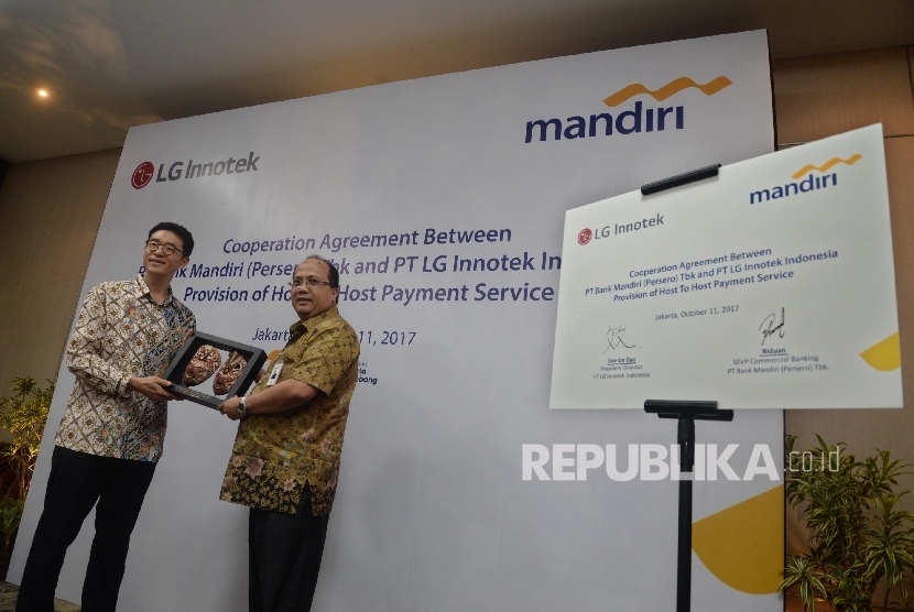 Direktur Utama LG Innotek Indonesia Bae Un Gyo (kiri), memberikan cinderamata kepada Senior EVP Commercial Banking Bank Mandiri Riduan seusai penandatanganan perjanjian kerjasama layanan perbankan di Jakarta, Rabu (11/10).