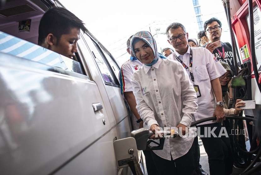 Direktur Utama Pertamina Nicke Widyawati (tengah) mengisi BBM ke kendaraan pelanggan di SPBU Coco Kuningan, Jakarta, Senin (3/9). 