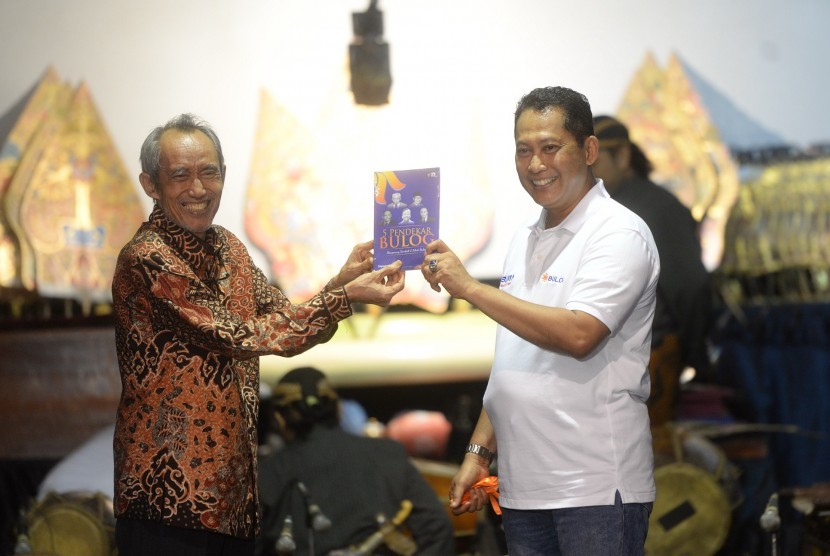 Direktur Utama Perum Bulog Budi Waseso (kanan) menerima buku saat peringatan HUT ke-52 Bulog di Jakarta, Sabtu (27/4). Selain peluncuran tujuh produk unggulan Bulog, acara juga menampilkan pagelaran wayang kulit bersama Ki Warseno Slenk.