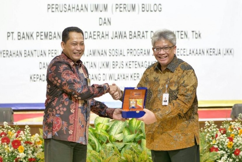 Direktur Utama Perum Bulog Budi Waseso (kiri) dan Dirut Bank BJB Yuddy Renaldi berbagi cinderamata dalam ajang penandatanganan Memorandum of Understanding (MoU) di Kantor Pusat Perum Bulog, Jakarta, Rabu (31/7).     