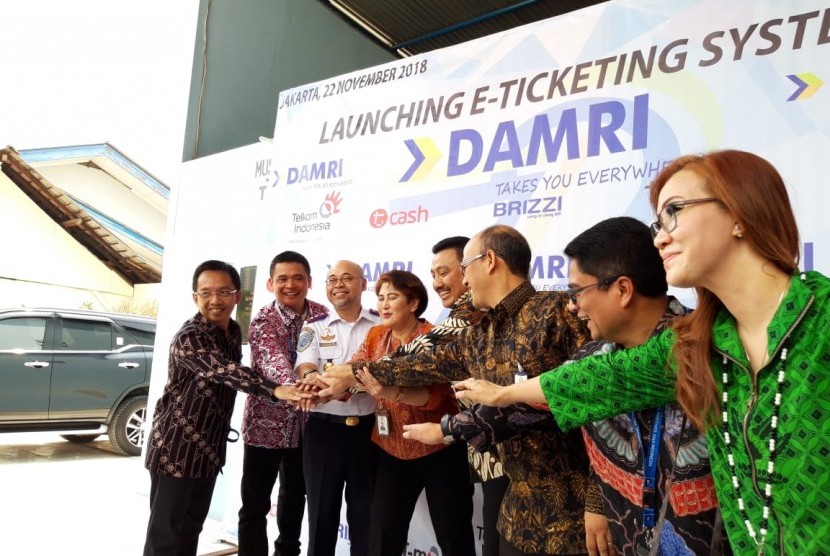 Direktur Utama Perum Damri Setia N Milatia Moemin (tengah) bersama Kepala BPTJ Bambang Prihantono (baju putih), Direktur Enterprise and Business Service PT Telkom Dian Rachmawan (batik merah bata) menunjukkan uang elektronik di Pool Damri Kemayoran, Jakarta pada Kamis (22/11). 