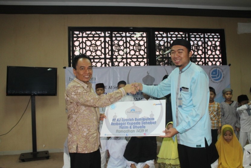 Direktur Utama PT AJ Syariah Bumiputera - Sudadi memberikan bantuan secara simbolis kepada Cecep - Daarut Tauhid Peduli, disaksikan anak-anak yatim dan dhuafa, di aula Masjid Daarut Tauhid, Cipaku, Jakarta Selatan, Senin (4/6).