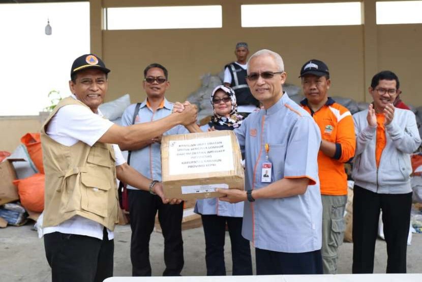 Direktur Utama PT Pos Indonesia (Persero) Gilarsi W Setijono (kanan) menyerahkan secara simbolis kiriman bantuan dari masyarakat melalui Program Pos Peduli Bencana Gempa Lombok kepada Kepala Bidang Kedaruratan dan Logistik BPBD Provinsi NTB Agung Pramuja, Rabu (29/8).