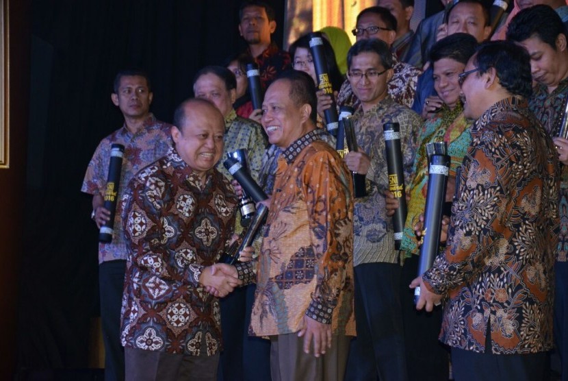 Direktur Utama PT Pupuk Kalimantan Timur (PKT), Bakir Pasaman (kiri), menerima penghargaan Platinum kategori Organisasi Besar Barang Sektor Kimia Dan Serba Aneka,  pada ajang SNI Award yang diserahkan oleh Menristekdikti, Mohamad Nasir (tengah), di Jakarta