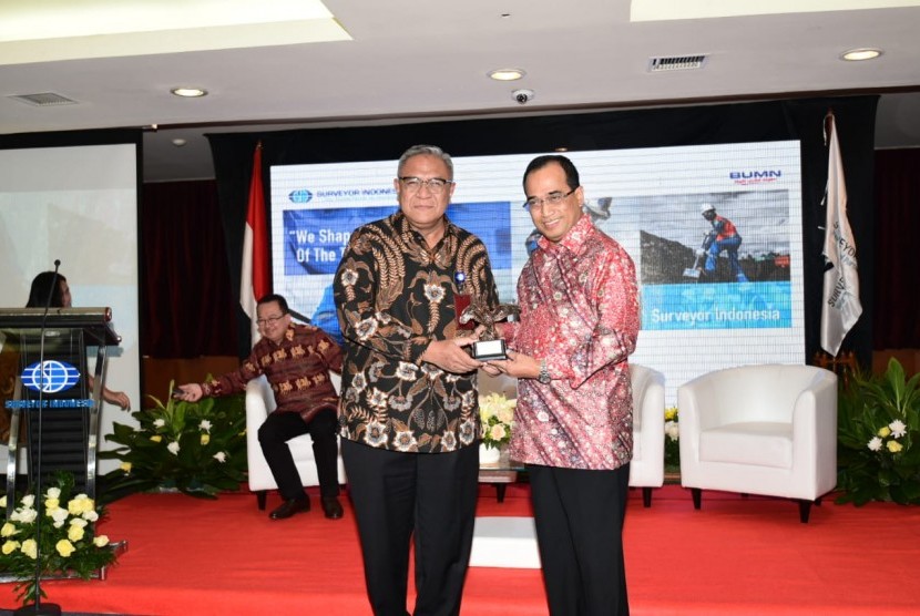 Direktur Utama  PT Surveyor Indonesia (Persero) Dian M. Noer (kiri) menyerahkan kenang-kenangan kepada Menteri Perhubungan, Budi Karya Sumadi, pada acara Surveyor Indonesia Outlook 2019  di Jakarta, Jumat (19/10).