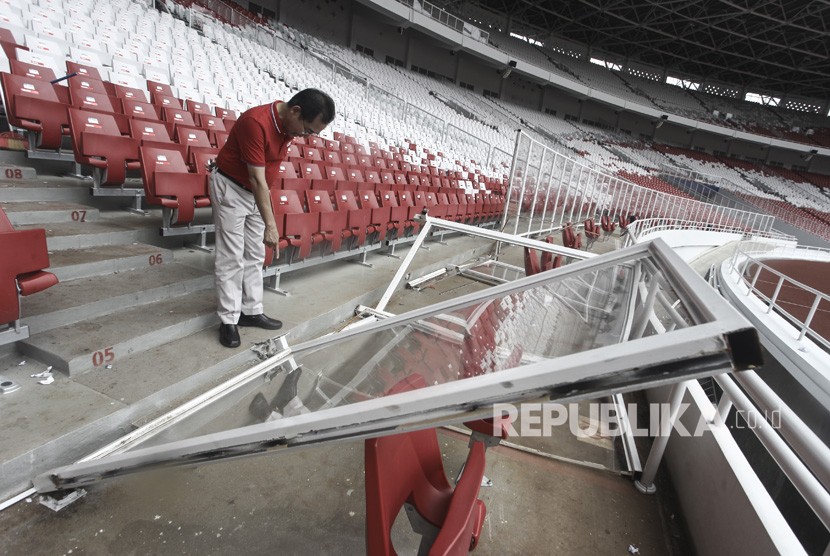 Direktur Utama Pusat Pengelola Kompleks Gelora Bung Karno (PPK GBK) Winarto memeriksa kondisi pagar pembatas lapangan yang rusak di Stadion Utama GBK, Senayan, Jakarta, Ahad (18/2).