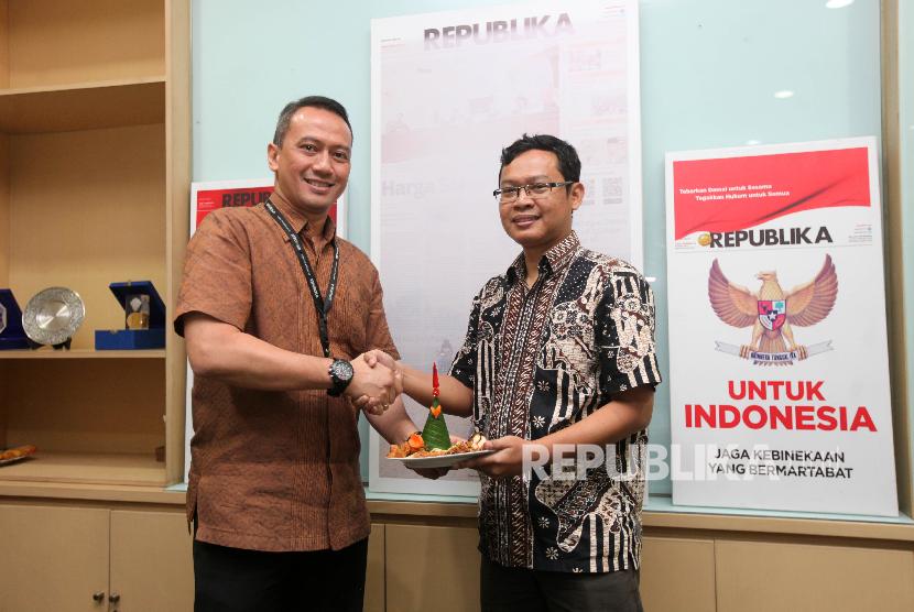 Direktur Utama Republika Media Mandiri Agoosh Yuoosran (kiri) menyerahkan potongan tumpeng kepada CEO Xeranta Mobile Heru Hariyanto (kanan) saat soft Launching Aplikasi Ihram di Kantor Harian Republika, Jakarta, Kamis (25/10). 