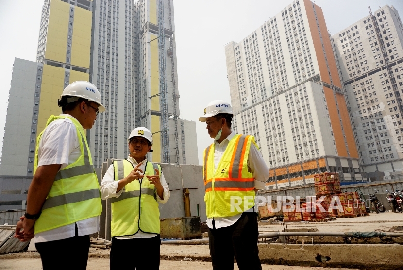 Dirjen Penyediaan Perumahan Kemen PUPR Syarif Burhanuddin (tengah) berbincang dengan Pejabat Pembuat Komitmen Rumah Susun Bertingkat Tinggi Kemayoran Ditto Ferakhim (kiri) dan Kepala Satuan Kerja Pengembangan Perumahan Erizal usai meninjau proyek pembangunan rusun wisma atlet Kemayoran, Jakarta, Rabu (19/7).