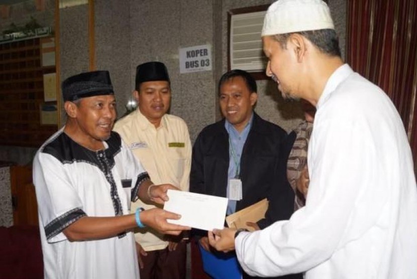 Dirjen Penyelenggaraan Haji dan Umrah, Anggito Abimanyu menyerahkan santunan kepada 35 jamaah calon haji yang kopernya terbakar.