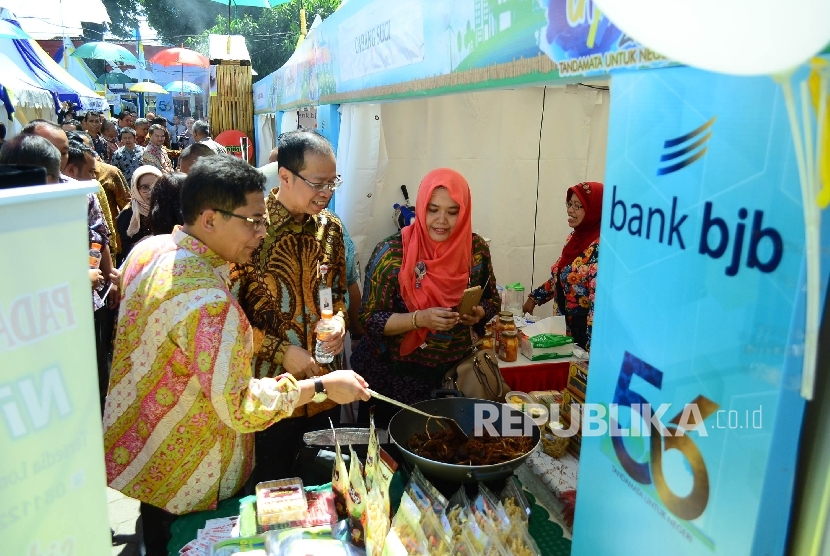 Dirut Bank BJB Ahmad Irfan dan Kepala OJK Regional Jabar Sarwono (kiri) meninjau stand Usaha Mikro Kecil dan Menengah (UMKM) pada Bazaar UMKM dan Travel Fair 2017 di halaman kantor pusat Bank BJB, Kota Bandung, Kamis (18/5). 