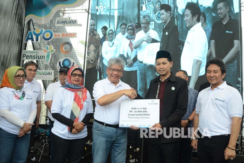 Dirut Bank BJB Yuddy Renaldi (tengah) secara simbolis memberikan Kredit Usaha Rakyat (KUR) pada Festival Literasi Keuangan (FLK), di Cikapundung River Spot, Kota Bandung, Sabtu (26/10).