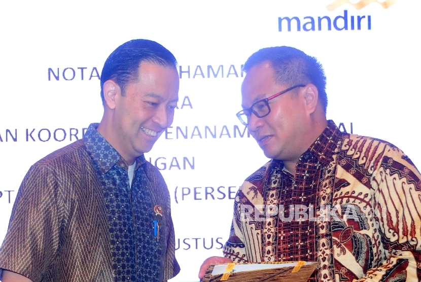 Dirut Bank Mandiri, Kartika Wiroatmojo (kanan) berbincang dengan Kepala Badan Koordinasi Penanaman Modal (BKPM) Thomas Lembong (kiri) usai penandatanganan MoU kerjasama untuk investasi di Gedung BKPM, Jakarta, Selasa (9/8). 