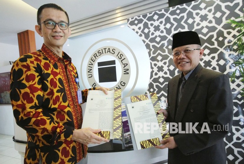 Dirut Bank Syariah Bukopin (BSB) Saidi Mulia Lubis (kiri) dan Rektor Unisba Prof Edi Setiadi (kanan) memgang perjanjian kerjasama usai penandatanganan MoU tentang pemanfaatan produk dan jasa penbankan syariah milik BSB, di Gedung Rektorat Unisba, Kota Bandung, Kamis (19/4).