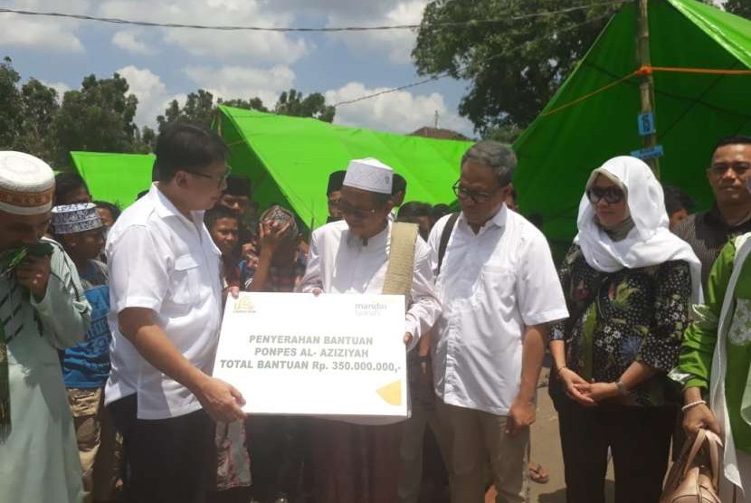 Dirut Bank Syariah Mandiri (BSM) Toni Eko Boy Subari menyerahkan bantuan kepada Ponpes Al Aziziyah di Dusun Kapek, Desa Gunungsari, Kecamatan Gunungsari, Kabupaten Lombok Barat, NTB, yang rusak akibat gempa, Senin (10/9).   