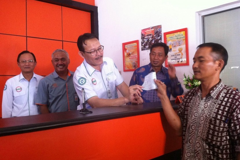 Dirut BPJS Kesehatan Fachmi Idris (tengah) menyerahkan bukti pembayaran dengan sistem payment point online bank (PPOB) di Kantor Pos Congeang, Kabupaten Sumedang, belum lama ini. 