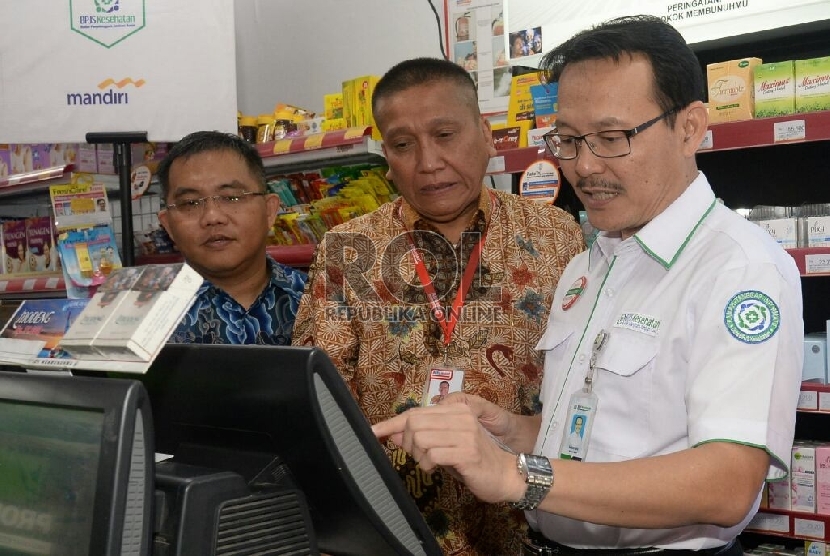 Dirut BPJS Kesehatan Fahmi Idris (kanan) bersama Senior EVP Transaction Banking Bank Mandiri Rico Usthavia Frans (kiri) dan Direktur Corporate Affair Alfamart Solihin (tengah) melakakuan pembayaran iuran BPJS Kesehatan kerjasama Bank Mandiri dengan Alfamar