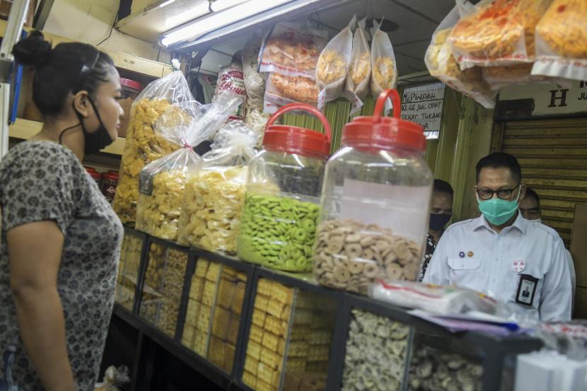 Dirut Perum Bulog Budi Waseso (kanan) berbincang dengan pedagang ketika meninjau kestabilan harga gula di Pasar Jatinegara, Jakarta, Jumat (15/5). Perum Bulog menargetkan penyerapan gabah petani setara beras mencapai 650 ribu ton hingga akhir Juni 2020.