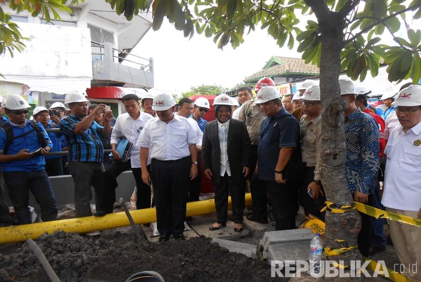 Dirut PGN Hendi Prio Santoso (kanan) berjalan bersama Menteri ESDM Sudirman Said serta Walikota Surabaya Tri Rismaharini saat meninjau pemasangan pipa jaringan gas (jargas) ke rumah tangga di Rungkut, Surabaya. (Republika/Rachmat Santosa Basarah)